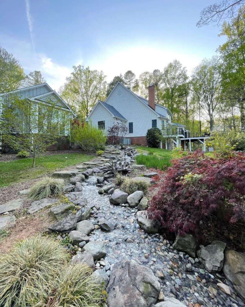 Wooded hillside pondless waterfall with natural stone and stream