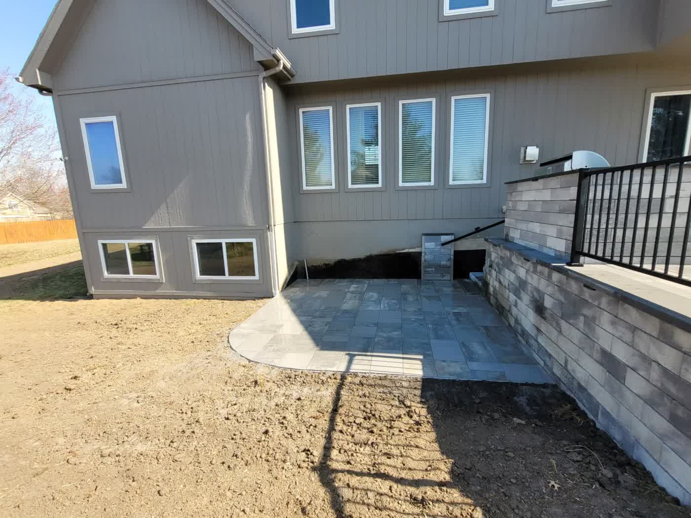 Custom paver patio with retaining wall and railing