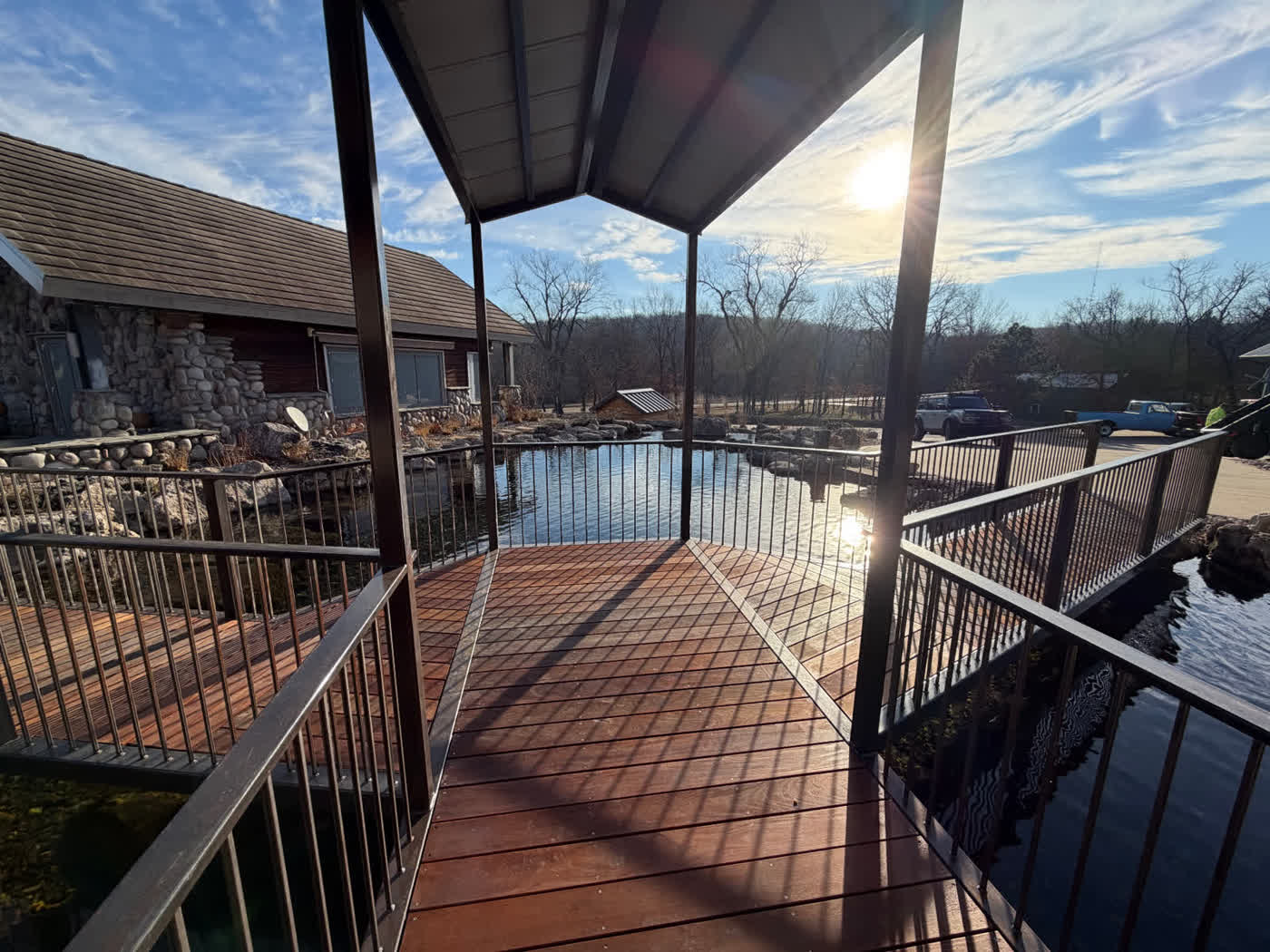 Covered deck overlooking swim pond at sunset