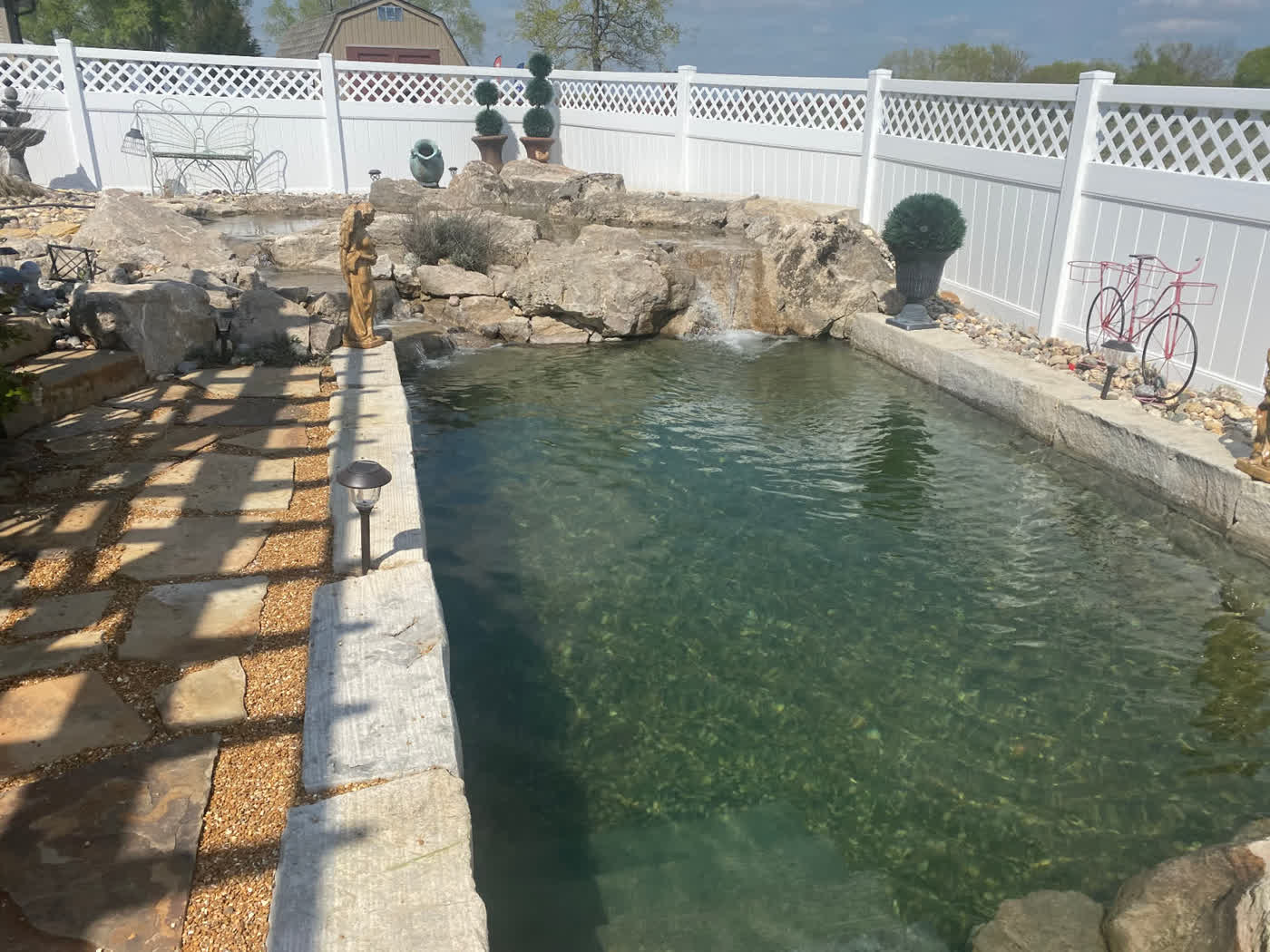 Swim pond with boulder waterfall and decorative accents