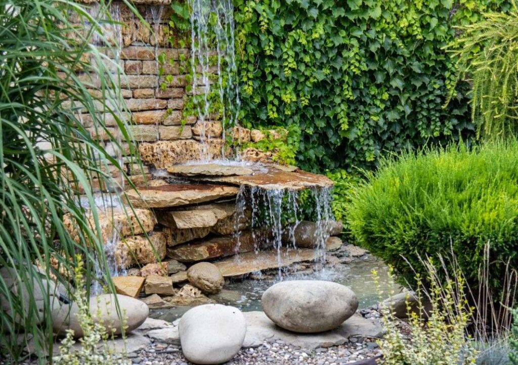 Garden waterfall with rocks and greenery