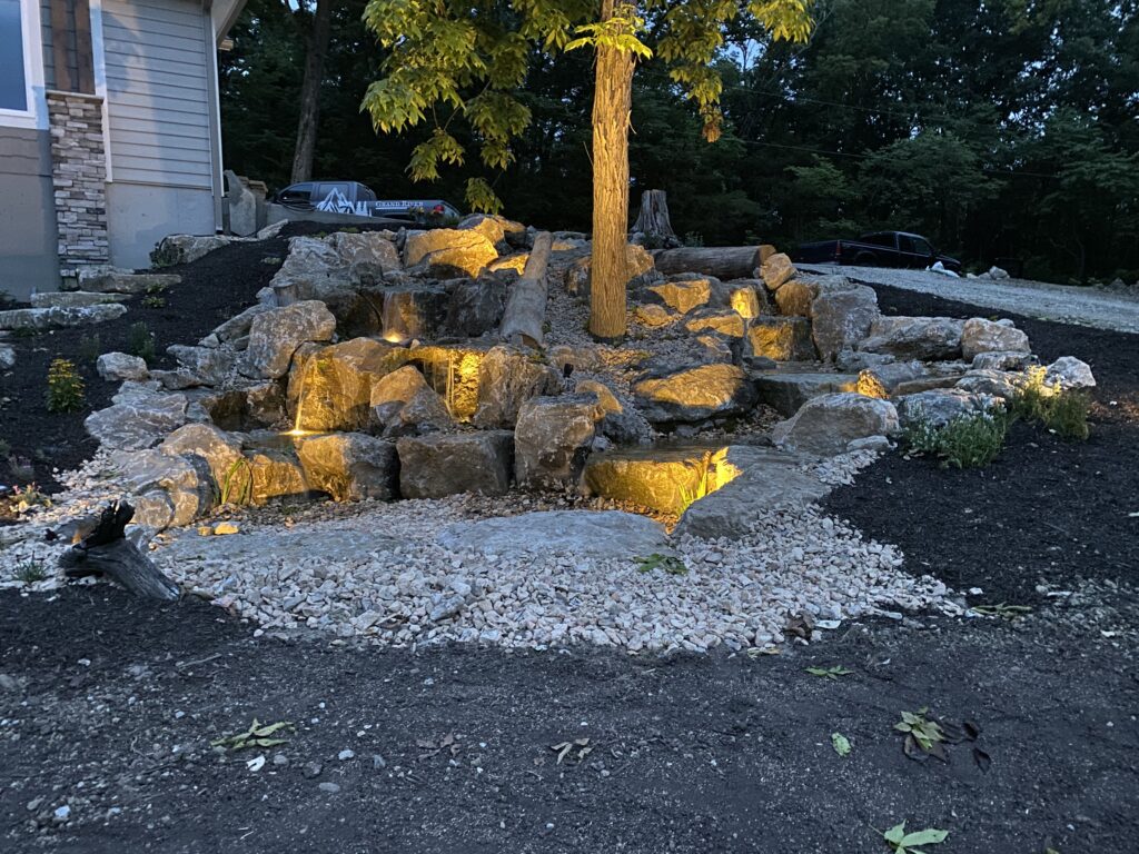 Custom pondless waterfall design with natural landscaping by Freedom Pondscapes